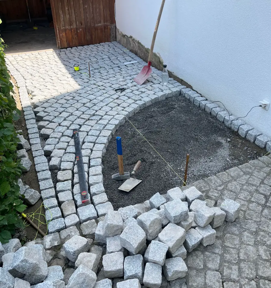 Hofzufahrt während der Verlegung: Setzlinie, Wasserwaage und lose Pflastersteine